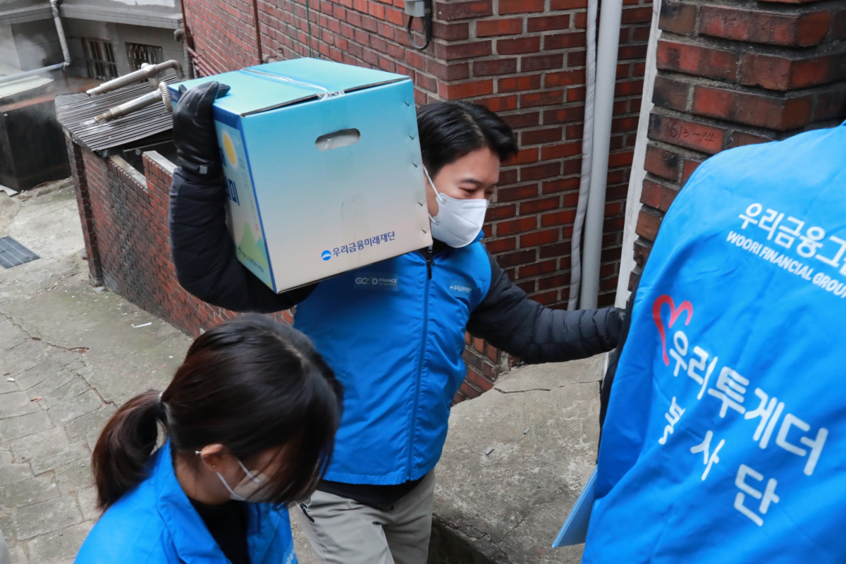 ▲우리금융미래재단 직원들이 설 명절을 맞아 독거어르신에게 '우리 새해 복꾸러미'를 전달하고 있다. (사진제공=우리금융미래재단)