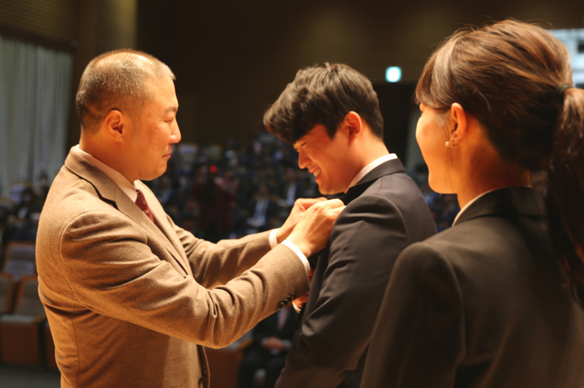 ▲구자은 LS그룹 회장(왼쪽)이 19일 안성시 LS미래원에서 2023년 LS 공채 신입사원들에게 회사 배지를 직접 달아주고 있다. (사진제공=LS그룹)