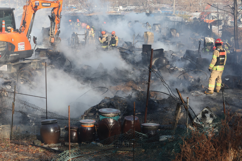 ▲20일 오전 화재가 발생한 서울 강남구 개포동 구룡마을 4구역에서 소방관들이 잔불을 끄고 있다. 설 연휴를 하루 앞두고 발생한 이 날 화재로 가건물 형태의 주택 약 60채가 소실되고 44가구에서 이재민 62명이 발생한 것으로 소방당국은 파악했다. (연합뉴스)
