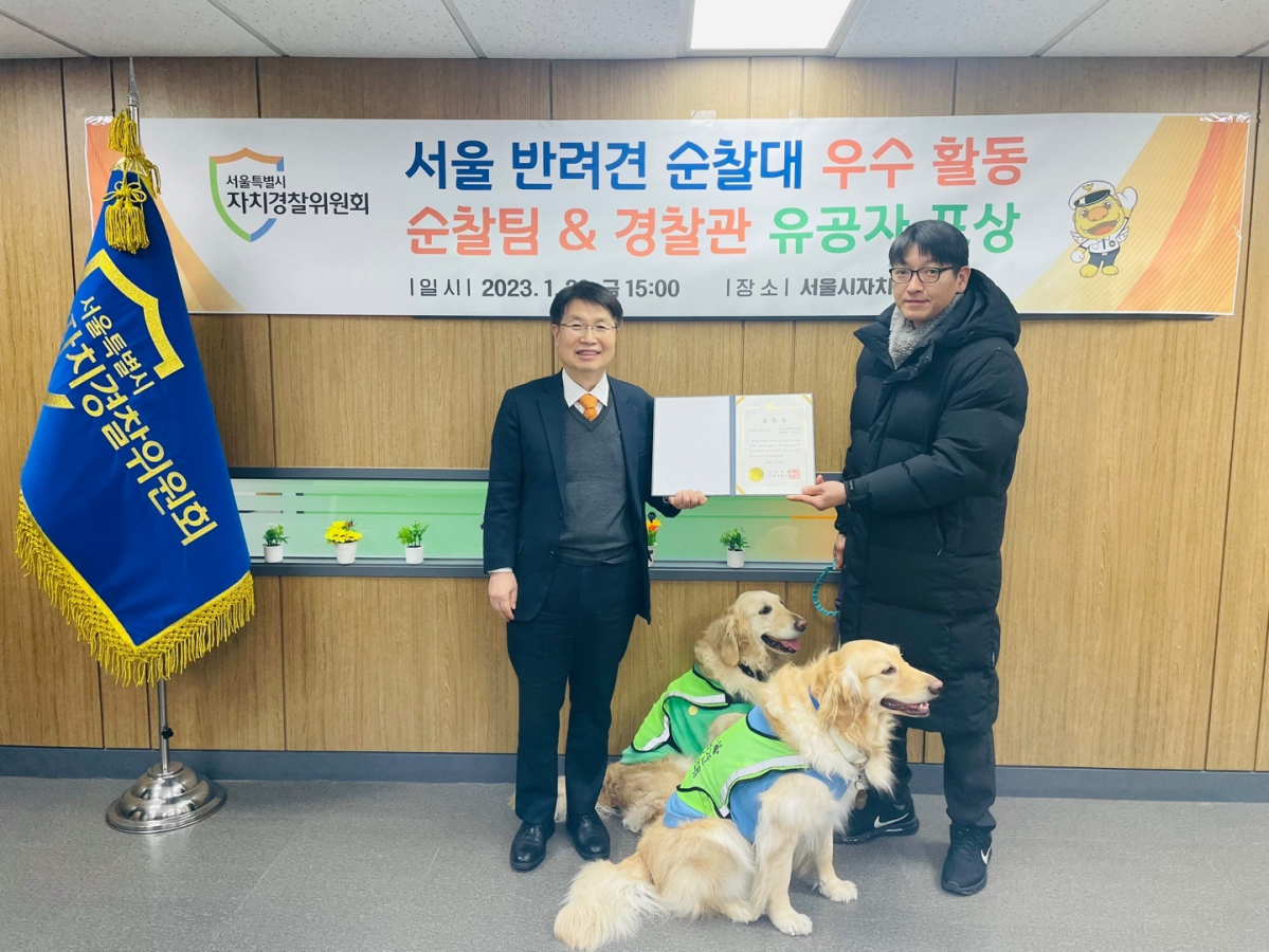 ▲반려견 순찰대 이정우님과 초이(뒤), 제니(앞)가 유공 표창을 받고 있다.  (사진제공=서울시)