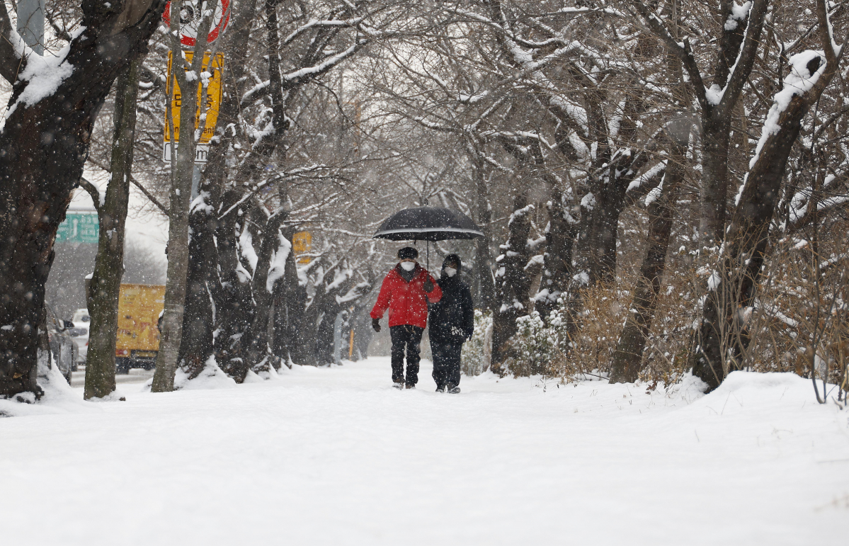 ▲서울 전역을 포함한 수도권 서남부와 충남서해안에 대설주의보가 내려진 26일 오전 서울 영등포구 샛강역 일대에서 시민들이 내리는 눈을 피해 발걸음을 재촉하고 있다. 조현호 기자 hyunho@