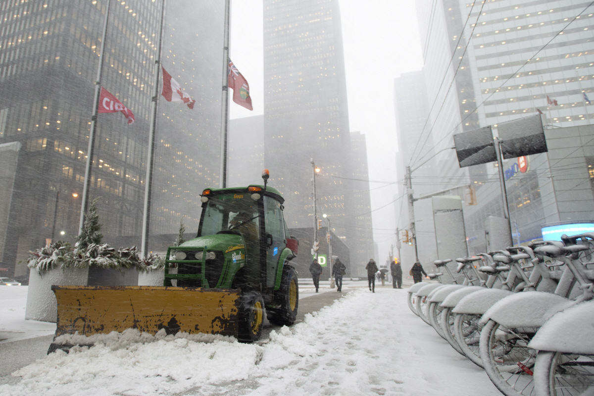 ▲캐나다 토론토에서 25일(현지시간) 한 노동자가 눈을 밀고 있다. 토론토/AP뉴시스
