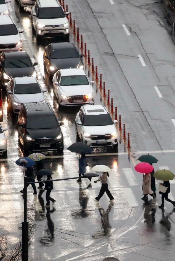 ▲13일 오전 광주 서구 치평동에서 출근길 시민들이 내리는 비에 우산을 쓰고 길을 건너고 있다. (연합뉴스)