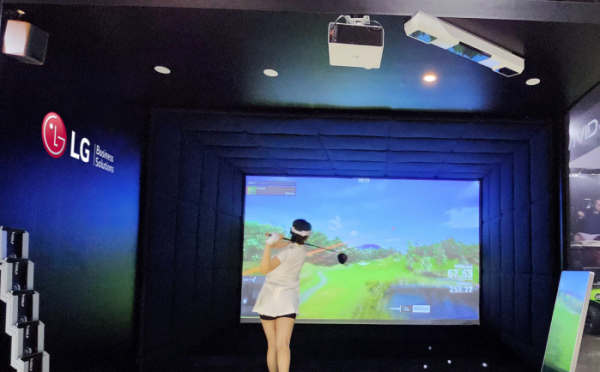 ▲천장에 설치된 프리미엄 상업용 프로젝터 'LG 프로빔 레이저 4K’를 활용해 조성한 스크린골프 체험존에서 LG전자 모델이 스크린 골프를 즐기는 모습. (사진제공=LG전자)