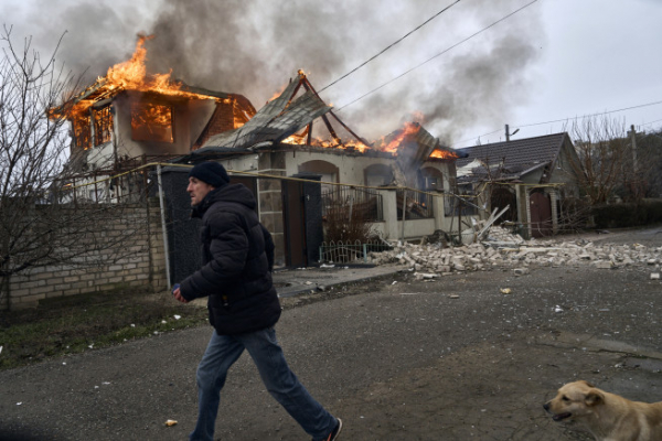▲6일(현지시간) 우크라이나 헤르손에서 한 시민이 러시아군의 포격으로 불에 타고 있는 집을 지나쳐 걷고 있다. 헤르손(우크라이나)/AP뉴시스 