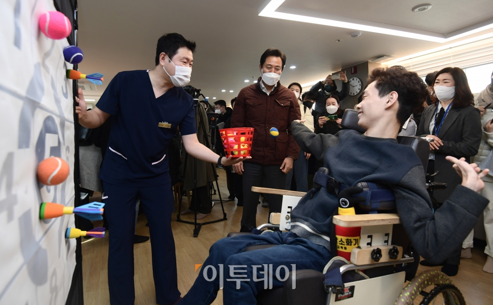 ▲오세훈 서울시장이 1일 오후 서울 강동구 중증뇌병변장애인 긴급수시돌봄 한아름 단기거주시설을 방문해 시설을 이용중인 김우솔 씨가 손근육 재활운동하는 모습을 살펴보고 있다. 조현호 기자 hyunho@