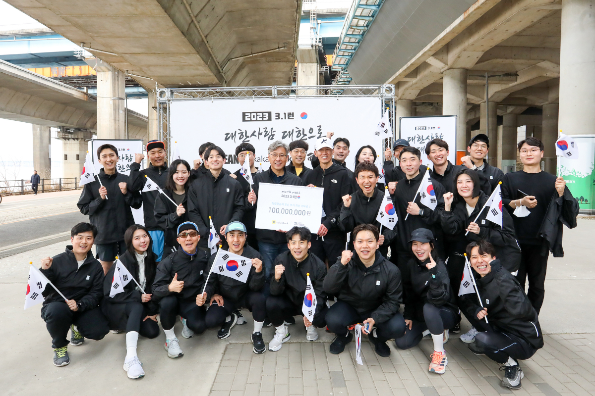 ▲카카오뱅크 임직원들이 서울시 성동구 한강변에서 진행된 독립유공자 후손을 위한 기부 마라톤 '3·1런'에 참여해 가수 션과 함께 기념 촬영을 하고 있다. (사진제공= 카카오뱅크)