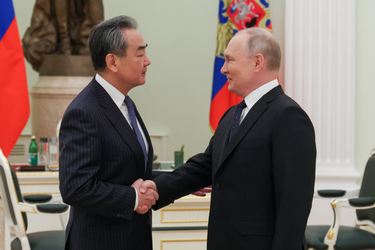 ▲왕이(왼쪽) 중국 공산당 중앙정치국 위원이 지난달 22일 블라디미르 푸틴 러시아 대통령과 인사하고 있다. 모스크바/타스연합뉴스
