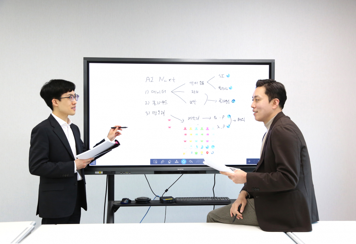 ▲멘토 오강호 신한투자증권 수석연구원이(오른쪽) 2022년 신규 입사직원 노승현 주임(왼쪽)을 코칭하고 있다. (사진 제공=신한투자증권)