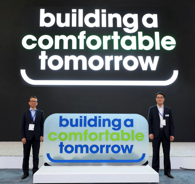 ▲현대건설기계가 14일(현지시간) 미국 라스베이거스에서 열린 ‘콘엑스포(ConExpo) 2023’에서 새로운 브랜드 아이덴티티(BI)와 슬로건을 발표했다. 새 슬로건 ‘building a comfortable tomorrow’ 앞에 선 (왼쪽)현대건설기계 최철곤 사장, 현대제뉴인 조영철 사장. (사진제공=현대건설기계)