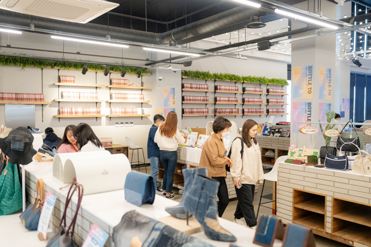 ▲제주삼다수 25주년 친환경 캠페인 '보틀 투 썸띵 굿즈' 내 플리마켓 ‘삼다공방’에서 시민들이 새활용 제품을 구경하고 있다. (사진제공=제주삼다수)