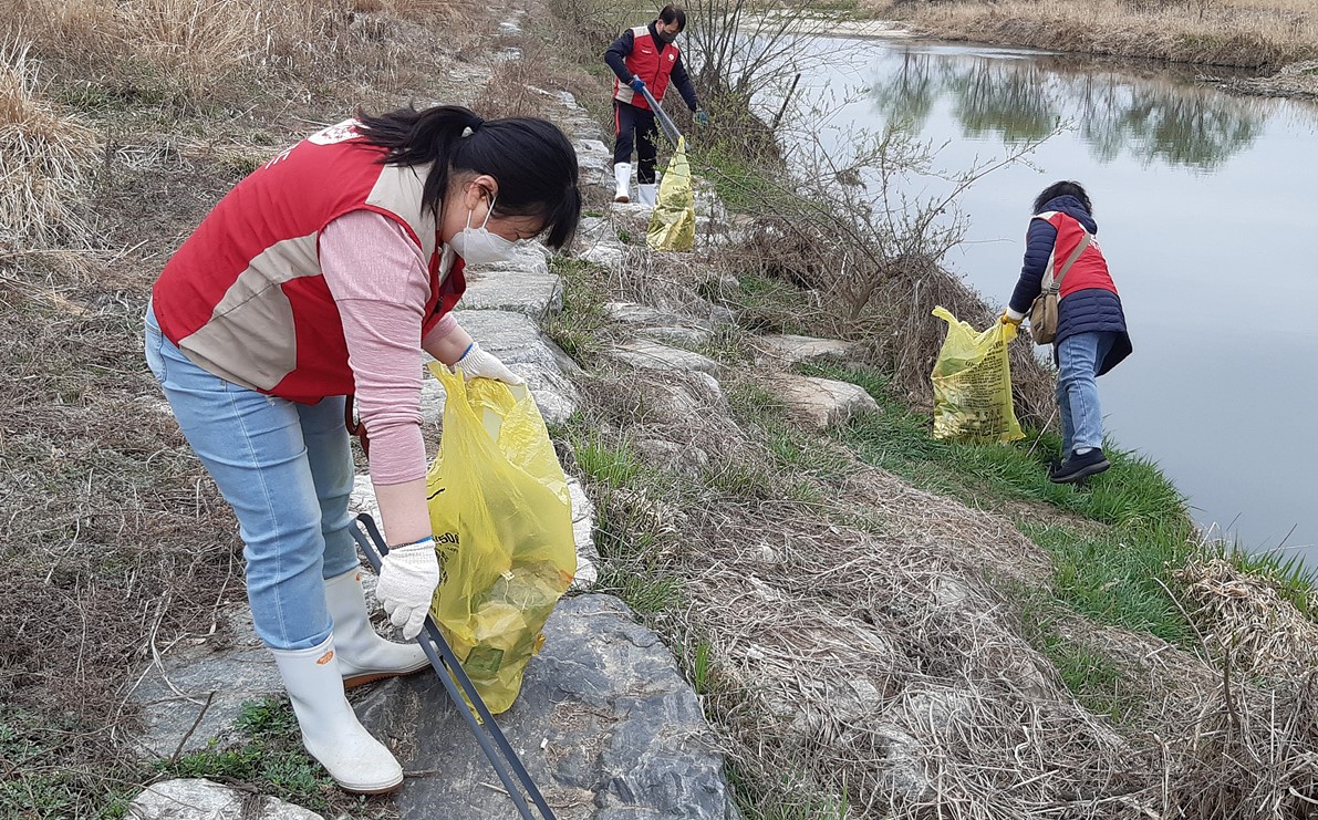 ▲송절천 주변을 정비하고 있는 샤롯데 봉사단 (사진제공=롯데제과)