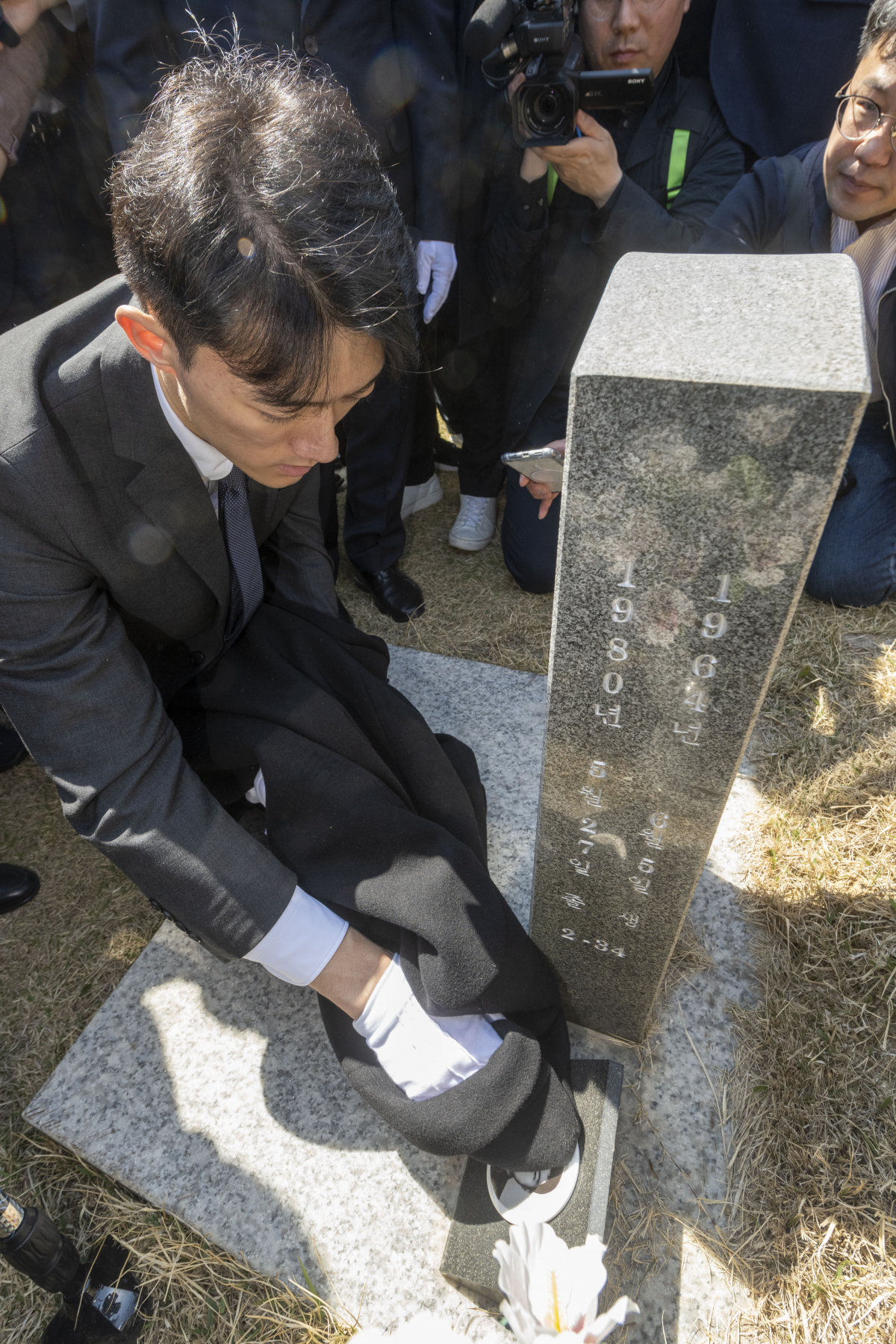 ▲전직 대통령 고(故) 전두환 씨의 손자 전우원 씨가 31일 오전 광주 북구 운정동 국립 5.18 묘지에서 고 문재학 열사 묘비를 닦고 있다.  (연합뉴스)