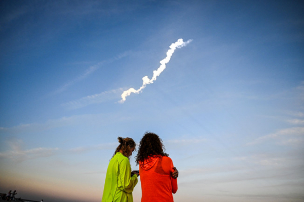 ▲미국 시민들이 하늘로 올라가는 팰컨9 로켓을 지켜보고 있다. (AFP/연합)