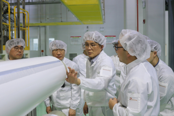 ▲김철중(가운데) SK아이이테크놀로지 사장이 14일 중국 창저우시 소재  생산공장을 방문해 관계자들과 생산 시설을 둘러 보고 있다. (사진제공=SK아이이테크놀로지)