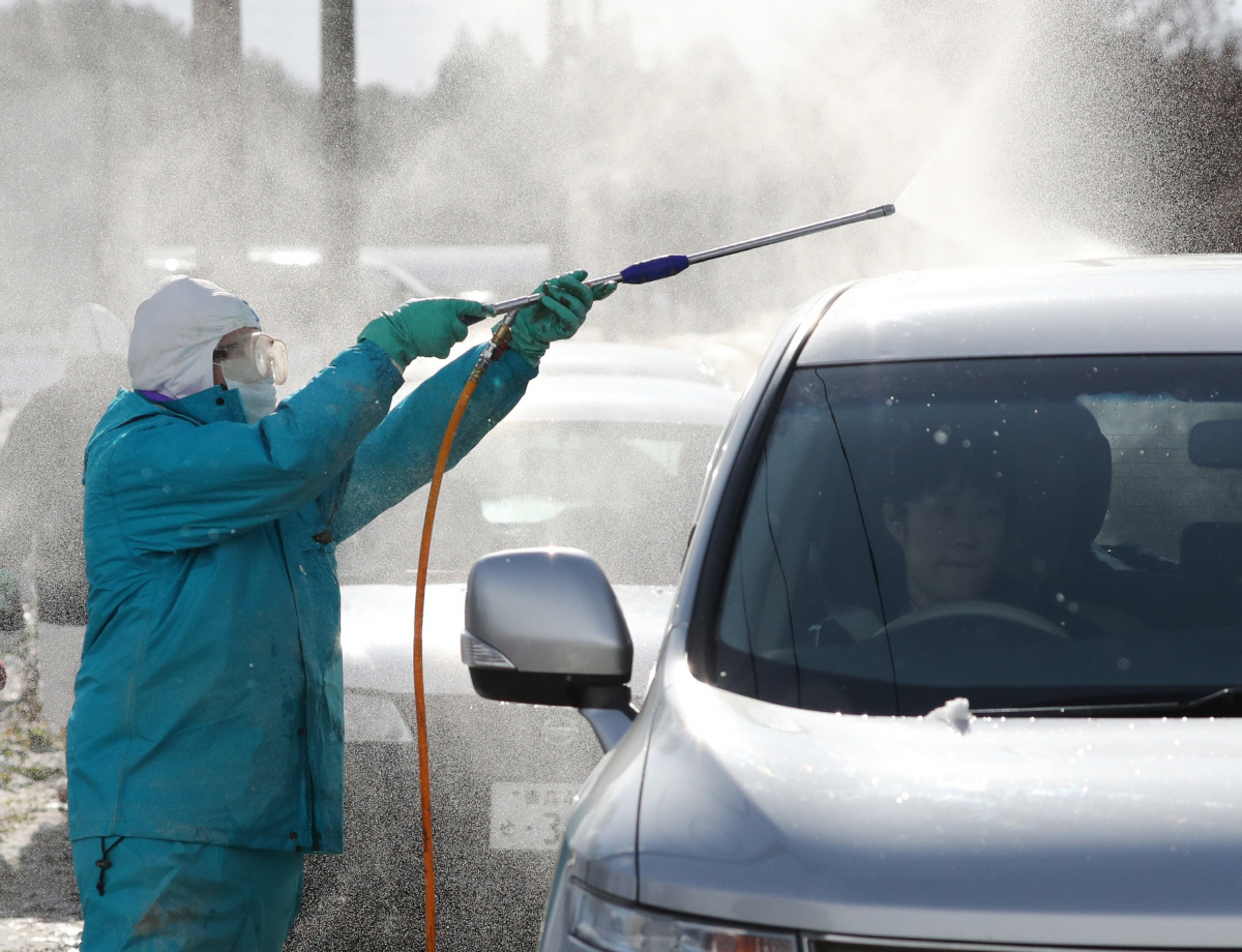 ▲일본 아오모리현에서 정부 관리가 닭 사육장 인근에서 차량을 소독하고 있다. 아오모리(일본)/AP뉴시스