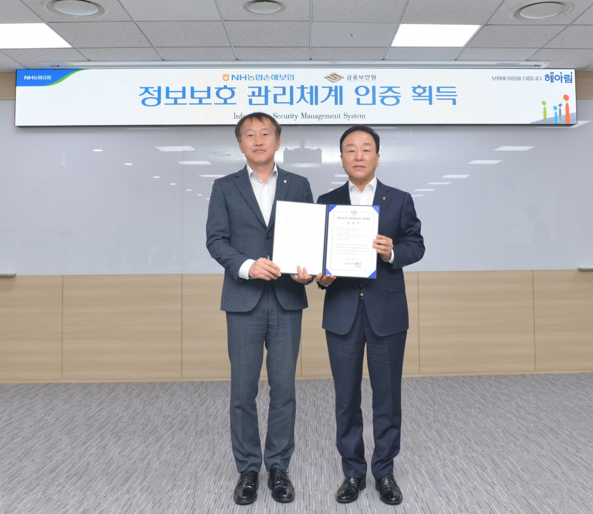 ▲NH농협손해보험(대표 최문섭)은 금융보안원으로부터 ‘대표 홈페이지 및 모바일 웹,앱 서비스 운영’에 대한 정보보호관리체계(ISMS) 인증을 취득했다고 13일 밝혔다. 농협손해보험 최문섭 대표이사(사진 오른쪽)가 기념사진 촬영을 하고 있다.