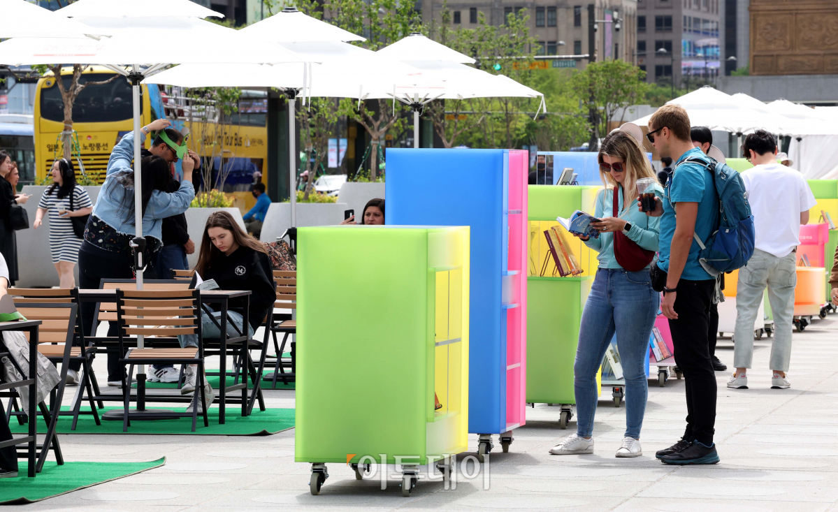 ▲세계 책의 날인 23일 서울 광화문광장을 찾은 외국인 관광객이 책을 읽고 있다. 서울시는 이날부터 11월까지 광화문광장과 서울광장에 각각 '광화문 책마당'과 '책읽는 서울광장'을 운영한다. 신태현 기자 holjjak@