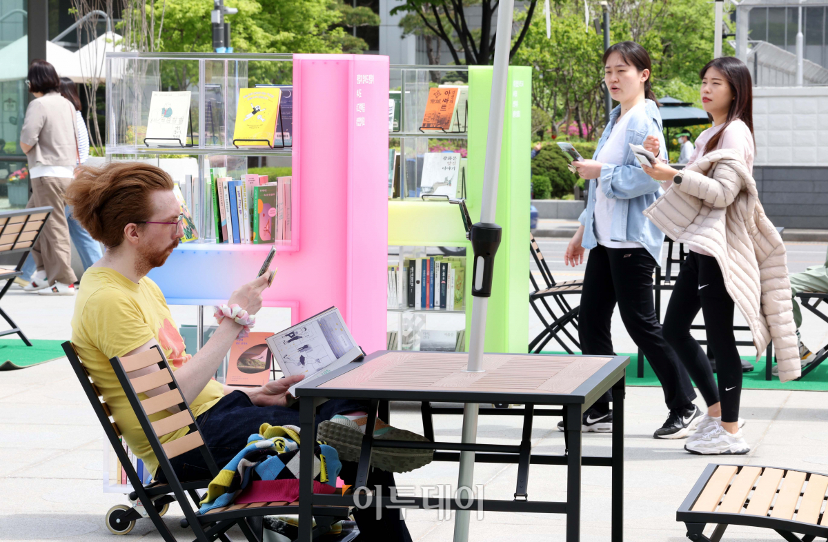 ▲세계 책의 날인 23일 서울 광화문광장을 찾은 외국인 관광객이 책을 읽고 있다. 서울시는 이날부터 11월까지 광화문광장과 서울광장에 각각 '광화문 책마당'과 '책읽는 서울광장'을 운영한다. 신태현 기자 holjjak@