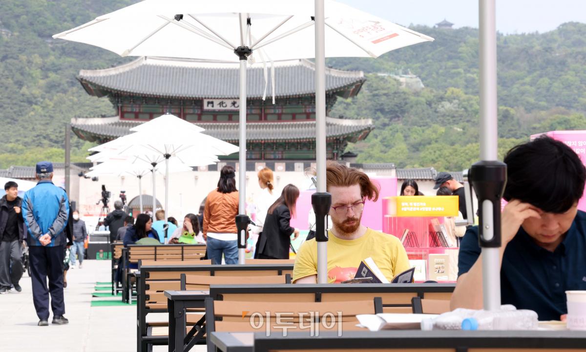 ▲세계 책의 날인 23일 서울 광화문광장을 찾은 외국인 관광객이 책을 읽고 있다. 서울시는 이날부터 11월까지 광화문광장과 서울광장에 각각 '광화문 책마당'과 '책읽는 서울광장'을 운영한다. 신태현 기자 holjjak@