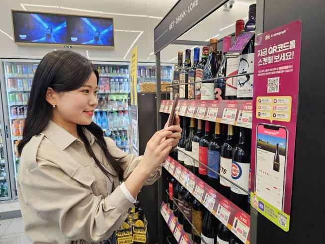 ▲한 소비자가 QR코드를 통해 와인 검색을 하고 있다. (사진제공=BGF리테일)