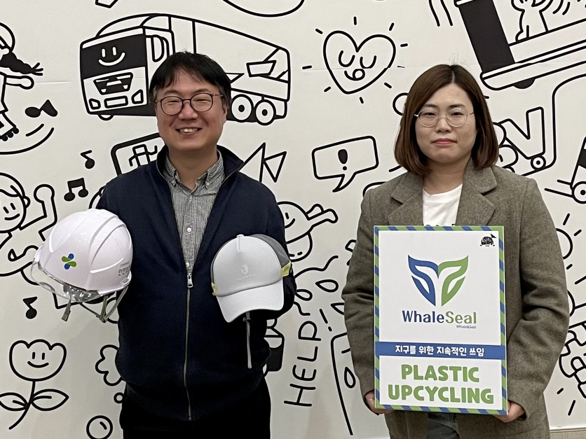 ▲ SK이노베이션이 지원·육성하고 있는 사회적기업 우시산 변의현 대표(사진 왼쪽)가 폐안전모와 폐안전모 및 폐페트병으로 만든 경량 안전모를 들고 기념사진을 촬영하고 있다. (사진제공=SK이노베이션)