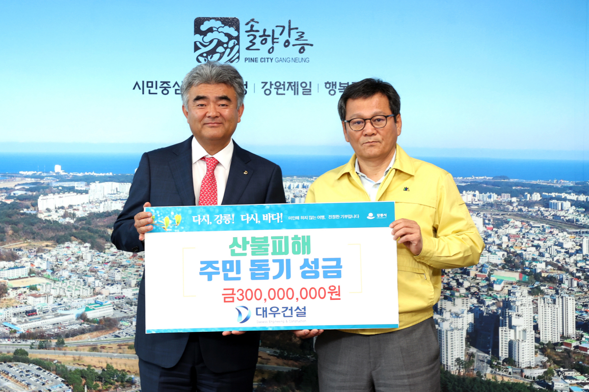 ▲정원주 중흥그룹 부회장(왼쪽)과 김홍규 강릉시장(오른쪽)이 성금 전달 후 사진촬영을 하고 있다 (자료제공=대우건설)