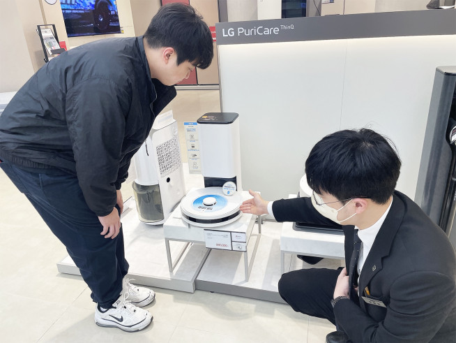 ▲전자랜드 타이푼에서 고객이 로봇청소기에 대한 설명을 듣고 있다. (사진제공=전자랜드)