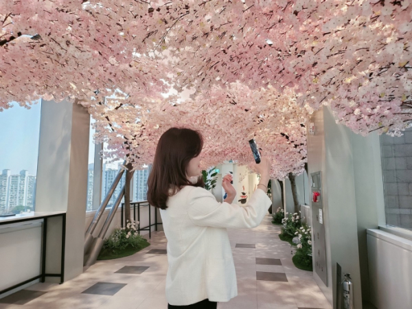 ▲신세계 경기점에서 한 고객이 벚꽃 길을 즐기고 있다. (사진제공=신세계)