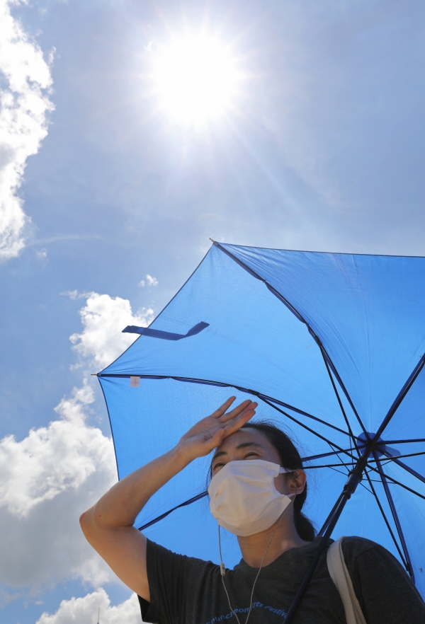 ▲On the afternoon of July 1 last year, when the heavy rain stopped and a heat wave warning was issued throughout Seoul, a citizen is covering the sun with a parasol near Seoul Plaza in Jung-gu, Seoul.  (Newsis)
