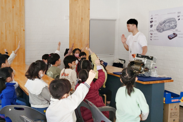 ▲ LG마그나 직원이 LG마그나가 생산한 부품을 교구로 활용해 학생들에게 전기차에 대해 설명하고 있다. (제공=LG전자)