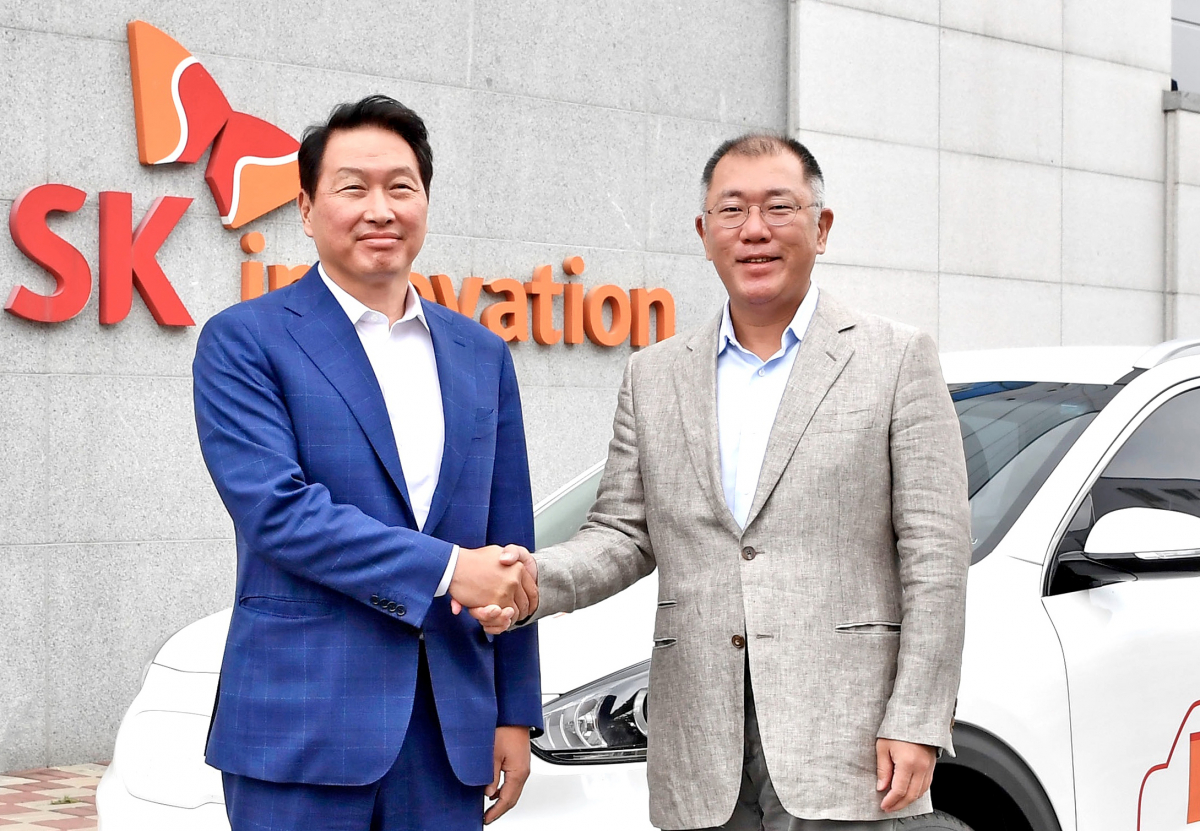 ▲정의선(오른쪽) 현대자동차그룹 회장과 최태원(왼쪽) SK그룹 회장이 기아차 니로EV 앞에서 악수하고 있다. (사진제공=현대차·SK)