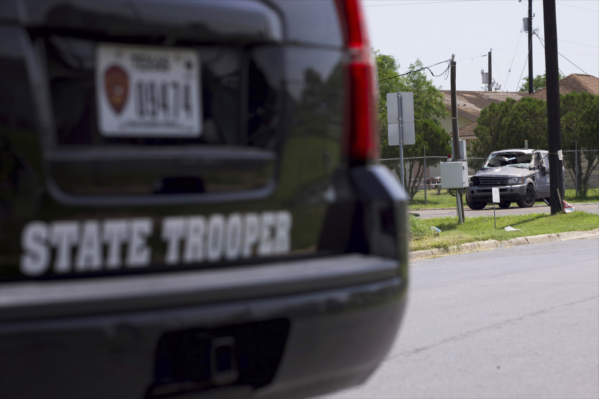 ▲미국 텍사스주 브라운스빌에서 7일(현지시간) 경찰차 너머로 파손된 사고 차량이 보인다. 브라운스빌(미국)/AP연합뉴스
