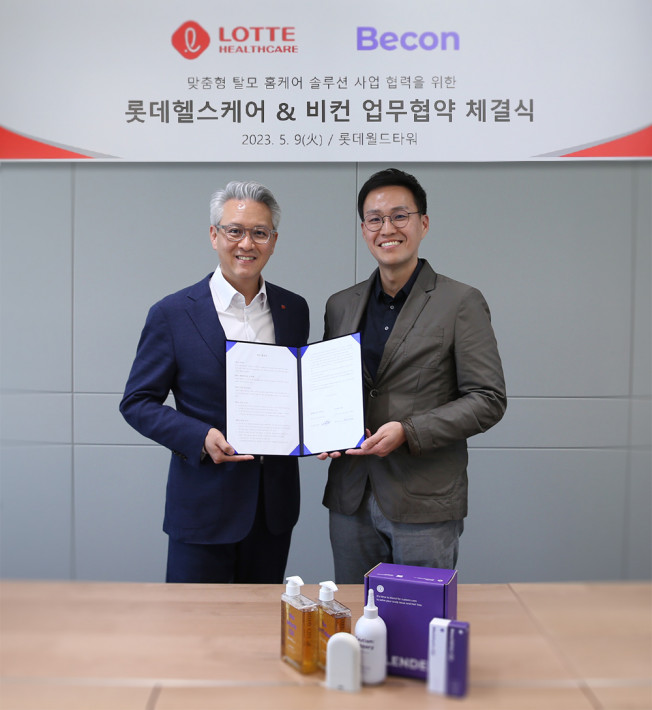 ▲(왼쪽부터) 우웅조 롯데헬스케어 사업본부장과 박민석 비컨 대표이사가 업무협약을 체결하고 기념촬영을 하고 있다. (사진제공=롯데헬스케어)