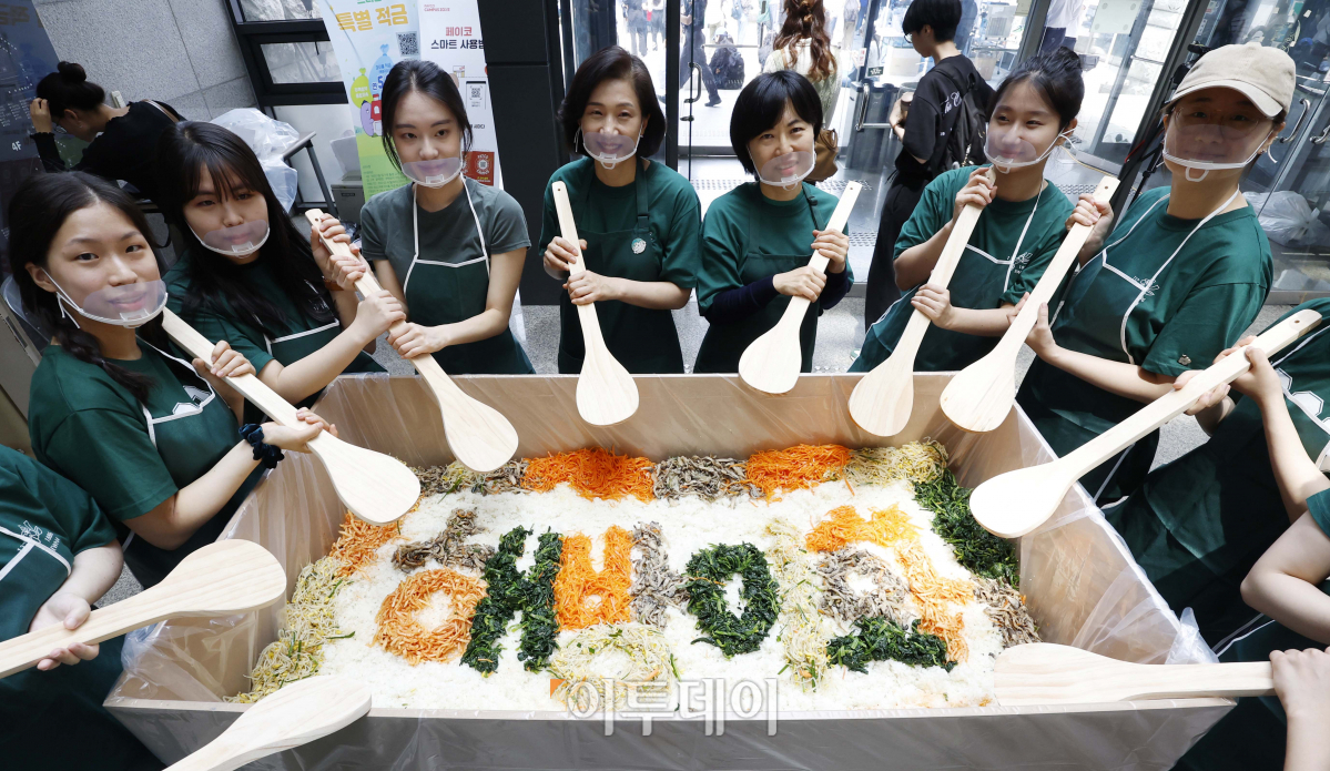 ▲10일 서울 서대문구 이화여자대학교에서 137주년 대동제를 기념해 열린 '해방! 이화인 한솥밥 먹기' 행사에서 교직원과 학생들이 기념촬영을 하고 있다. 해방! 이화인 한솥밥 먹기는 특대형 비빔밥을 비벼 재학생들에게 나눠주는 행사다. 조현호 기자 hyunho@