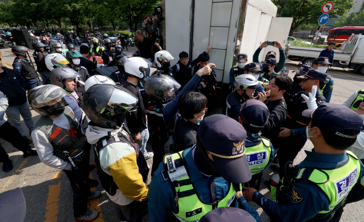 ▲민주노총 공공운수노조 라이더유니온지부 조합원들이 10일 서울 여의도 산업은행 앞에서 '라이더 자격제' 도입, 생활임금 보장 등을 촉구하는 ‘2023 라이더 대행진’을 열고 행진하려던 도중 경찰이 다섯대씩 끊어 출발할 것을 요구하자 항의하고 있다. 신태현 기자 holjjak@