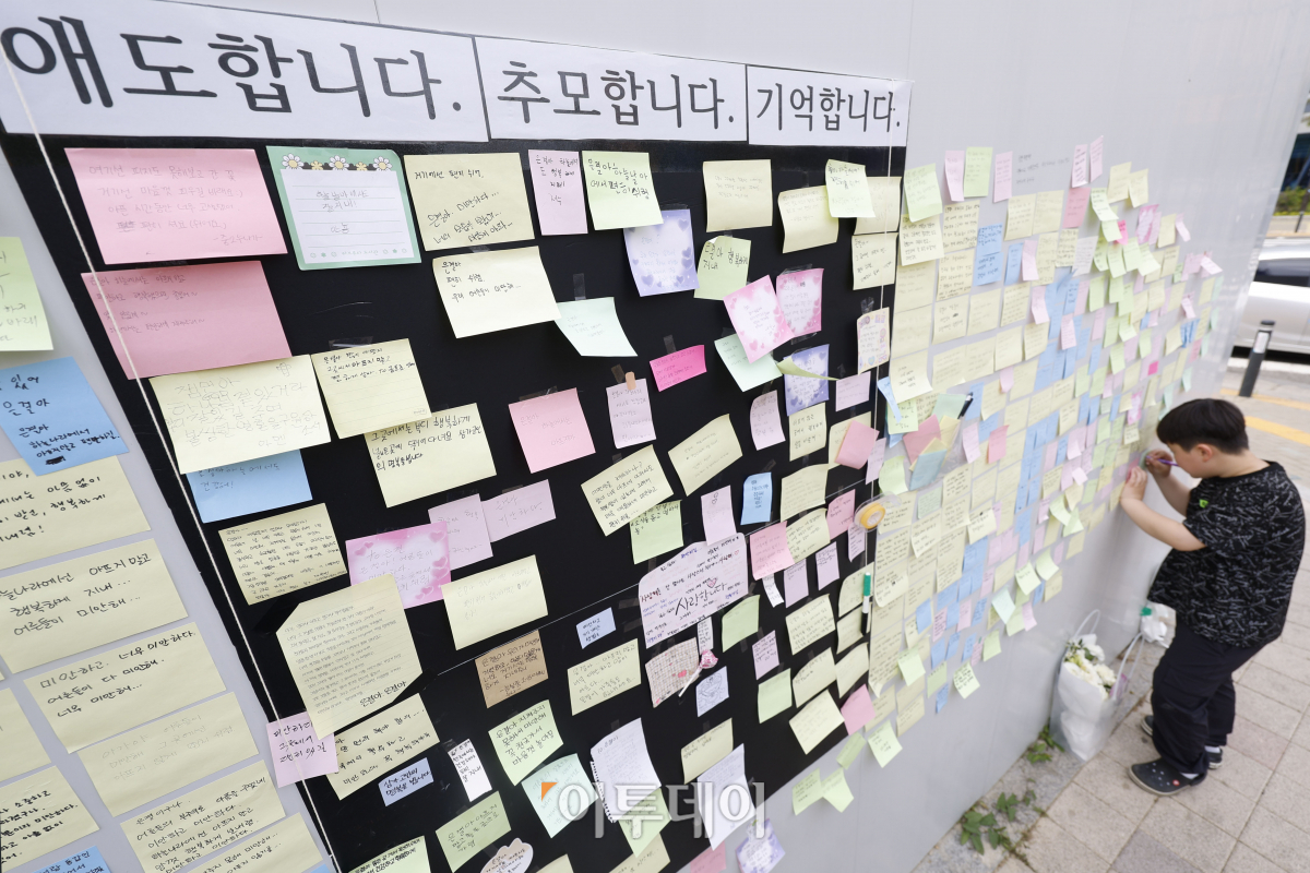 ▲경기도 수원시 권선구의 한 사거리에서 초등학생이 어린이보호구역(스쿨존)에서 시내버스에서 치여 숨지는 사고가 발생한 가운데 12일 사거리에 마련된 추모공간을 찾은 한 어린이가 초등학생을 추모하는 메시지를 붙이고 있다. 조현호 기자 hyunho@