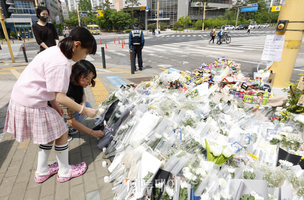 ▲경기도 수원시 권선구의 한 사거리에서 초등학생이 어린이보호구역(스쿨존)에서 시내버스에 치여 숨지는 사고가 발생한 가운데 12일 사거리에 마련된 추모공간을 찾은 시민들이 헌화하고 있다. 조현호 기자 hyunho@