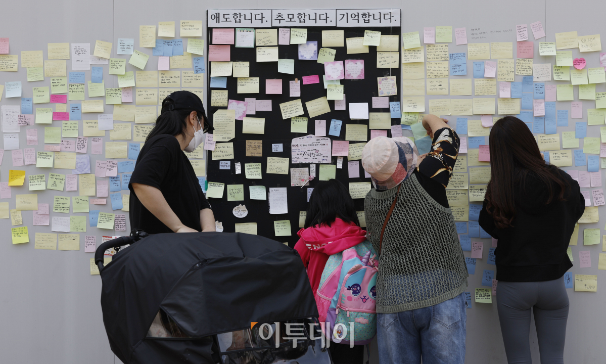 ▲경기도 수원시 권선구의 한 사거리에서 초등학생이 어린이보호구역(스쿨존)에서 시내버스에 치여 숨지는 사고가 발생한 가운데 12일 사거리에 마련된 추모공간을 찾은 시민들이 초등학생을 추모하는 메시지를 붙이고 있다. 조현호 기자 hyunho@