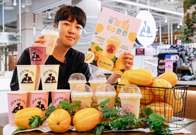 ▲서울 여의도 더현대 서울 지하 1층 ‘조앤더주스’ 매장에서 직원이 여름시즌 한정 신메뉴 ‘성주꿀참외주스’를 소개하고 있다. (사진제공=현대백화점)