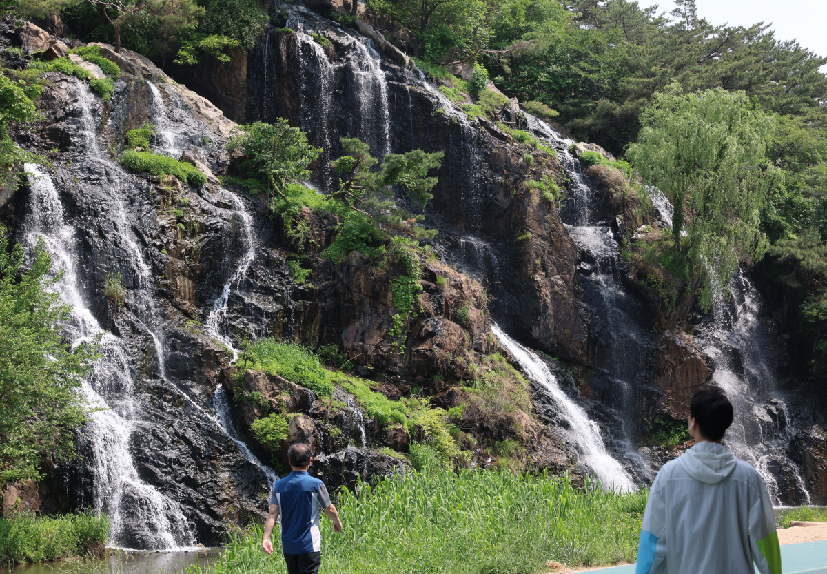 ▲전국이 평년기온을 웃도는 초여름날씨를 보인 15일 서울 서대문구 홍제천 인공폭포 앞 그늘에서 시민들이 더위를 식히고 있다. 신태현 기자 holjjak@