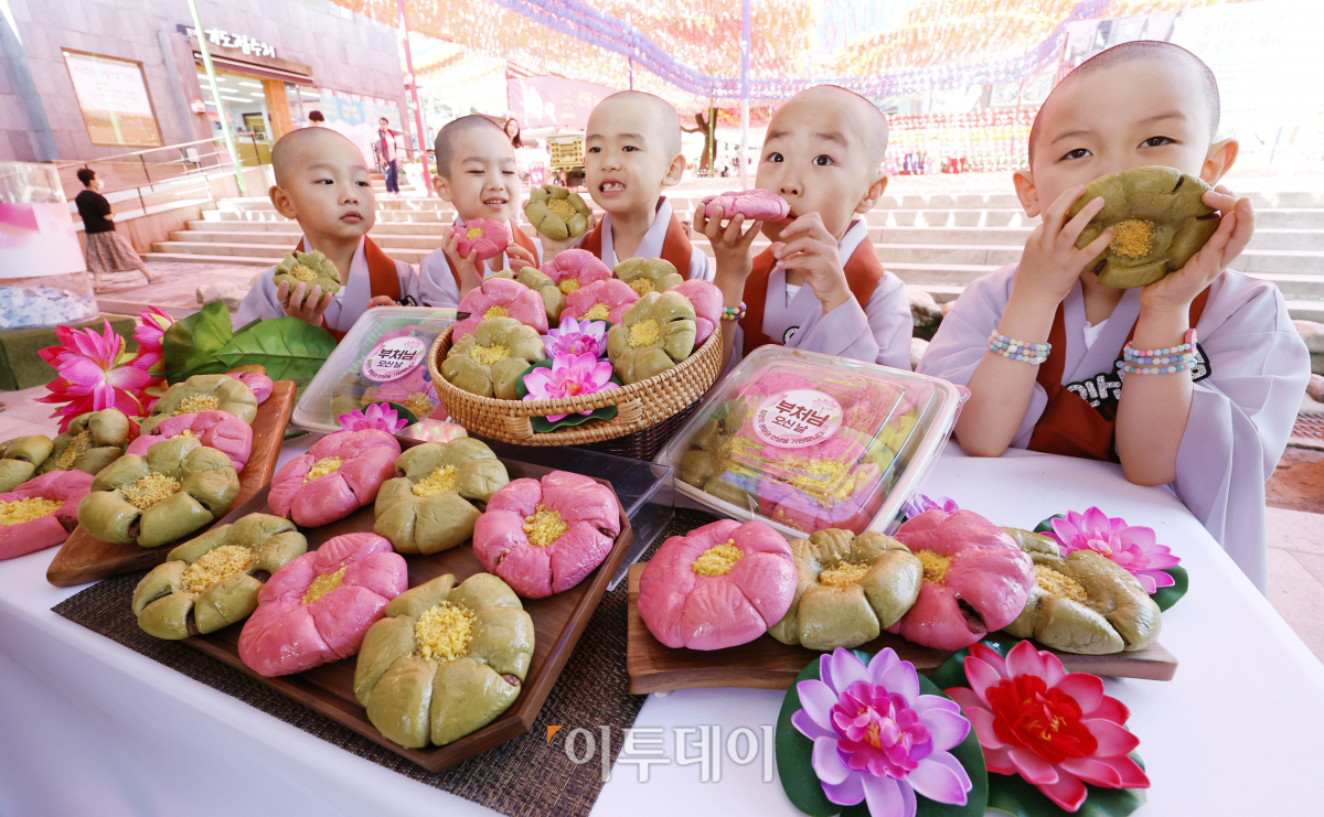 ▲23일 서울 종로구 조계사에서 단기출가 과정 '보리수 새싹학교' 동자승들이 부처님 오신날을 맞아 출시한 신세계푸드 '연꽃단팥빵'을 선보이고 있다. 우유, 계란, 버터 없이 100% 식물성 재료로 만든 연꽃닽팥빵은 백년초와 연잎 가루로 색을 내고 불교의 6가지 수행덕목을 상징하는 '육바라밀'을 6개의 꽃잎 모양에 담았다. 조현호 기자 hyunho@