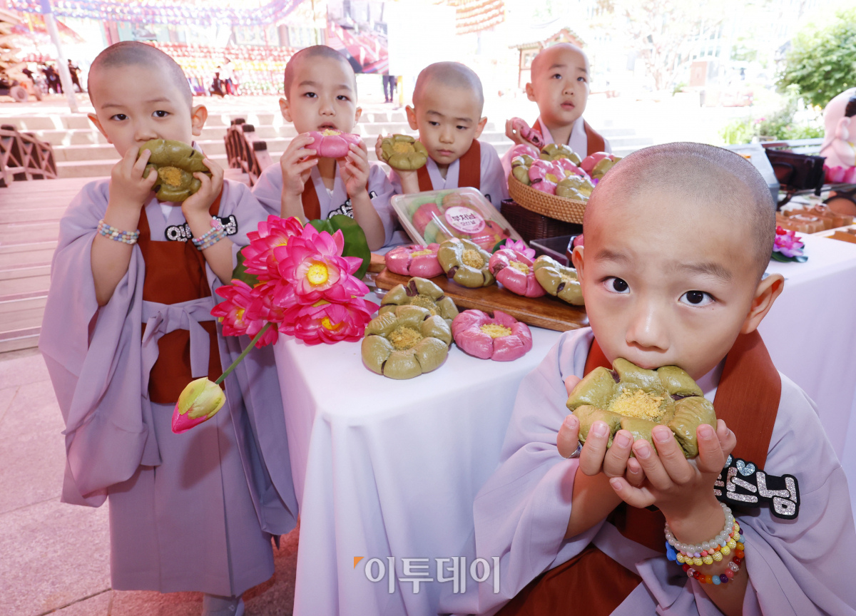 ▲23일 서울 종로구 조계사에서 단기출가 과정 '보리수 새싹학교' 동자승들이 부처님 오신날을 맞아 출시한 신세계푸드 '연꽃단팥빵'을 선보이고 있다. 우유, 계란, 버터 없이 100% 식물성 재료로 만든 연꽃닽팥빵은 백년초와 연잎 가루로 색을 내고 불교의 6가지 수행덕목을 상징하는 '육바라밀'을 6개의 꽃잎 모양에 담았다. 조현호 기자 hyunho@