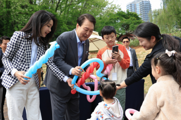 ▲윤석열 대통령과 김건희 여사가 4일 서울 용산 대통령실의 앞마당에 조성된 용산 어린이정원 개방행사에서 어린이들에게 풍선을 전달하고 있다. (연합뉴스)