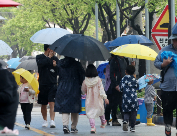 ▲5일 우산과 우의 차림의 탐방객들이 궂은 날씨에도 휴일을 즐기고 있다. (연합뉴스)