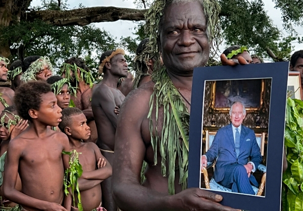 ▲영연방인 바누아투의 타나(Tanna)섬에서 한 부족민이 6일(현지시간) 찰스 3세 영국 국왕의 사진을 들고 있다. 타나(바누아투)/AFP연합뉴스
