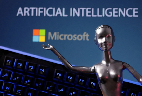 ▲마이크로소프트(MS) 로고가 나타난 컴퓨터 화면이 인간 모형의 피규어 뒤에 놓여 있다. 로이터연합뉴스
