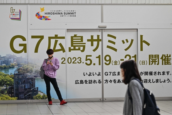 ▲일본 히로시마에서 주요 7개국(G7) 정상회의 개막 전날인 18일 한 남성이 기차역에서 G7 정상회의 홍보 문구 앞에 서 있다. 히로시마(일본)/AFP연합뉴스
