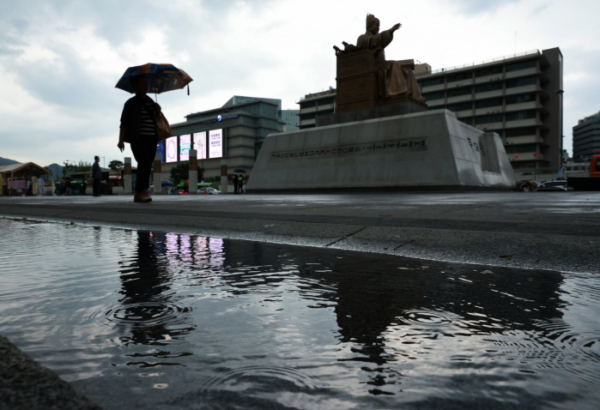 ▲하늘에 드리운 먹구름과 함께 비가 내린 18일 오후 서울 세종대로 광화문광장에서 관광객과 시민들이 우산을 쓴 채 이동하고 있다. (연합뉴스)