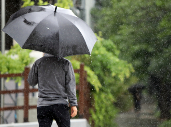 ▲6일 오후 대전 유성구 갑천에 장대비가 내리는 가운데, 시민들이 우산을 쓴 채 걸어가고 있다. (연합뉴스)